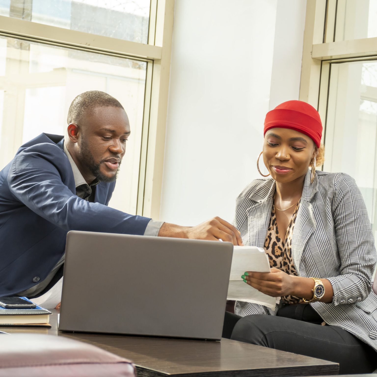 A young black businessman and woman going through some paperwork together